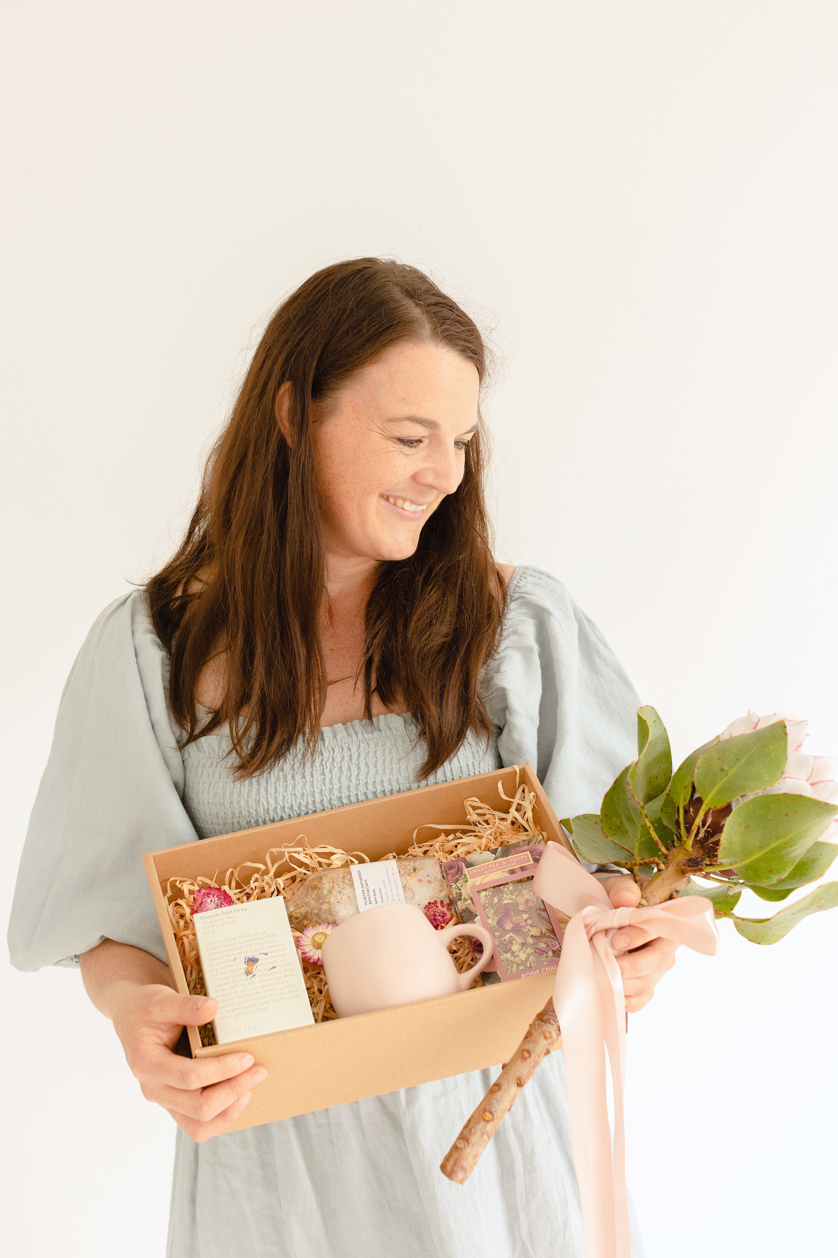 Woman holding mothering Sunday gift hamper and flower for delivery in Wagga Wagga
